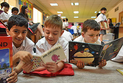 Children reading books at park House English School